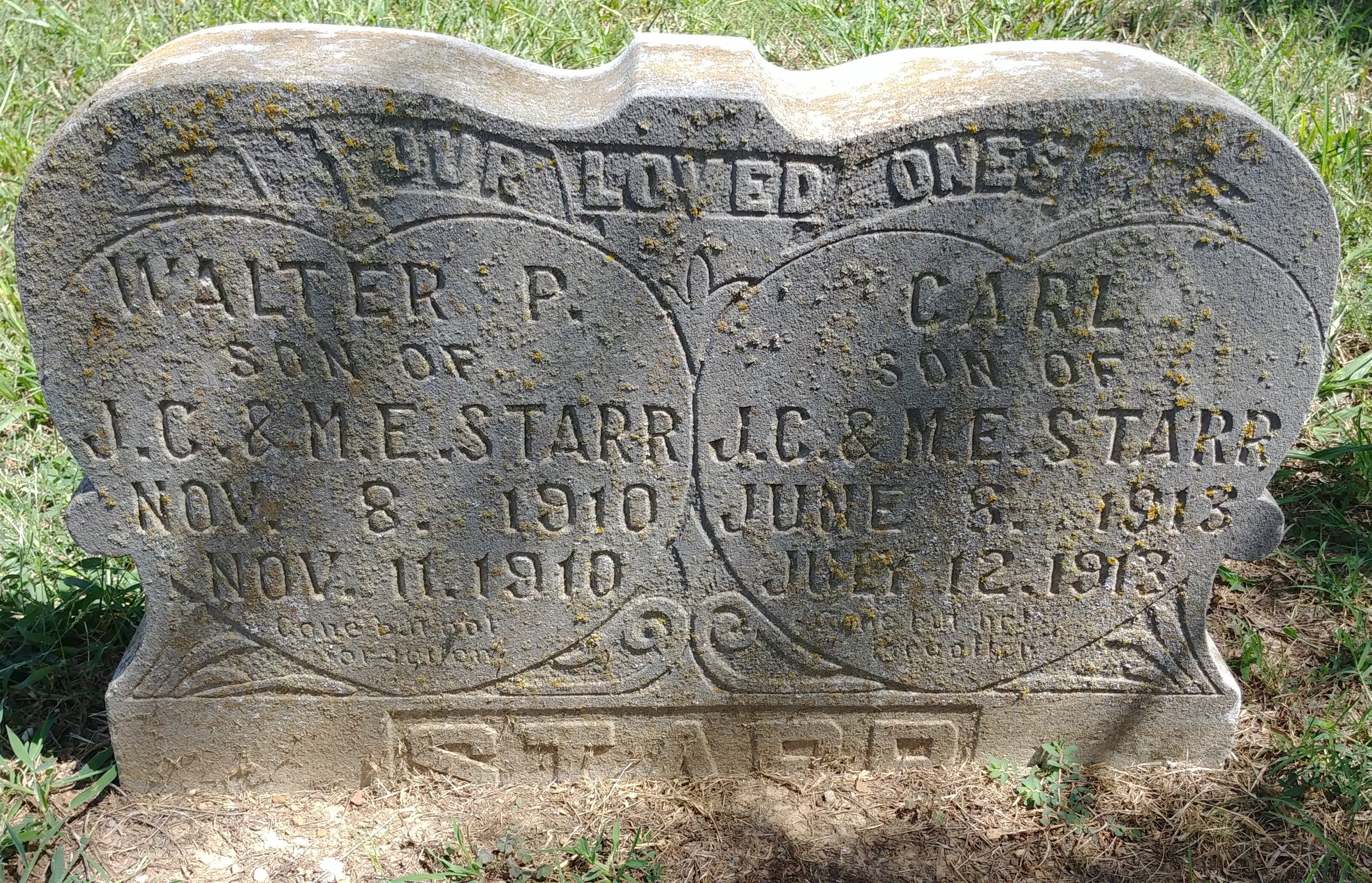 A tombstone with engraved text  Description automatically generated