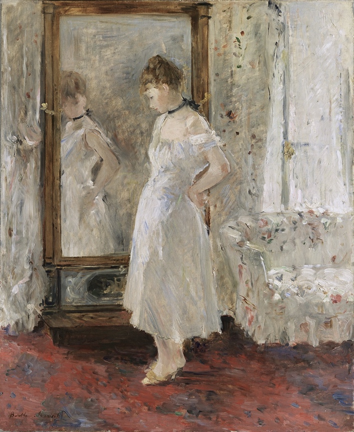 A person in a white dress standing in front of a mirror
Description automatically generated